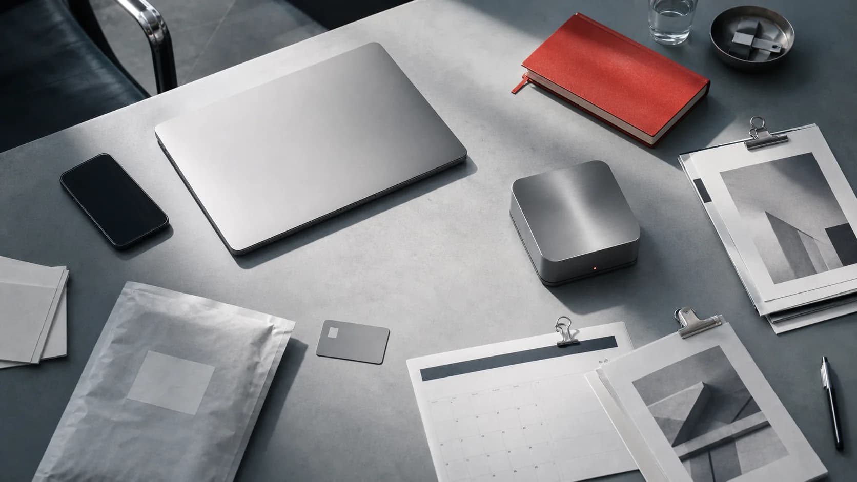 An organised operations table with a brushed-metal workstation and documents